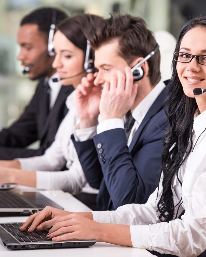 Side view of line of call centre employees are working.